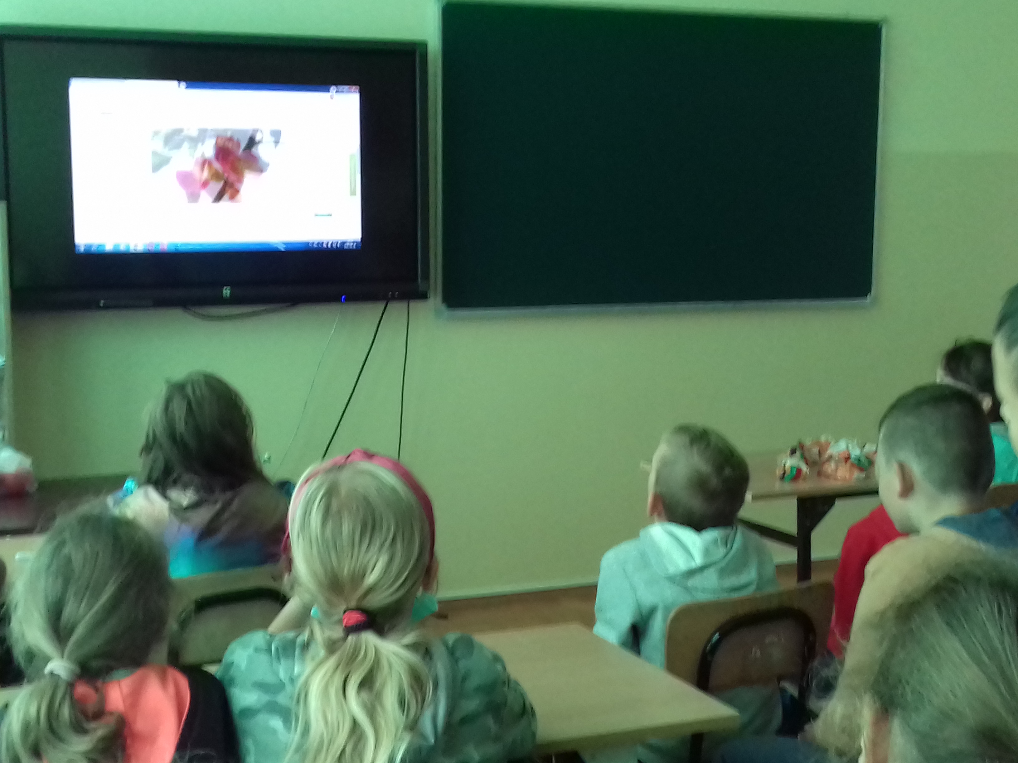 Uczniowie oglądający film o rozwoju jabłek.