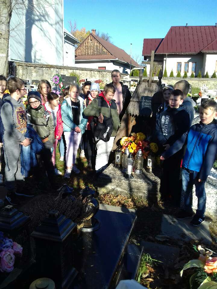 Uczniowie szkoły przy grobach zmarłych.